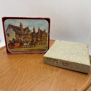 May include: A set of six coasters featuring a vintage illustration of a horse-drawn carriage in front of a quaint English inn. The coasters are in a red box with the text "Regent Series 6 C/Tails Ref. R46 WJ.B. LTD. Made in Britain OLD INNS (Wilson)".