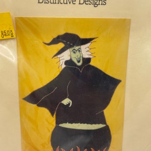 May include: A witch with white hair and a black pointed hat stands over a cauldron with green liquid and red flames. The background is yellow.