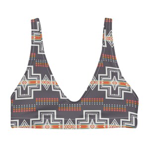 May include: A grey bikini top with a geometric pattern in shades of orange, red, white, and blue. The pattern is reminiscent of Native American designs.