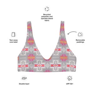 May include: A gray and white patterned bikini top with pink and orange accents. The top is made from recycled polyester and spandex blend fabric. It features removable paddings, a double-layer design, and UPF 50+ sun protection.