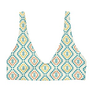 May include: A white bikini top with a geometric pattern in shades of blue, orange, and yellow. The pattern features squares and triangles.