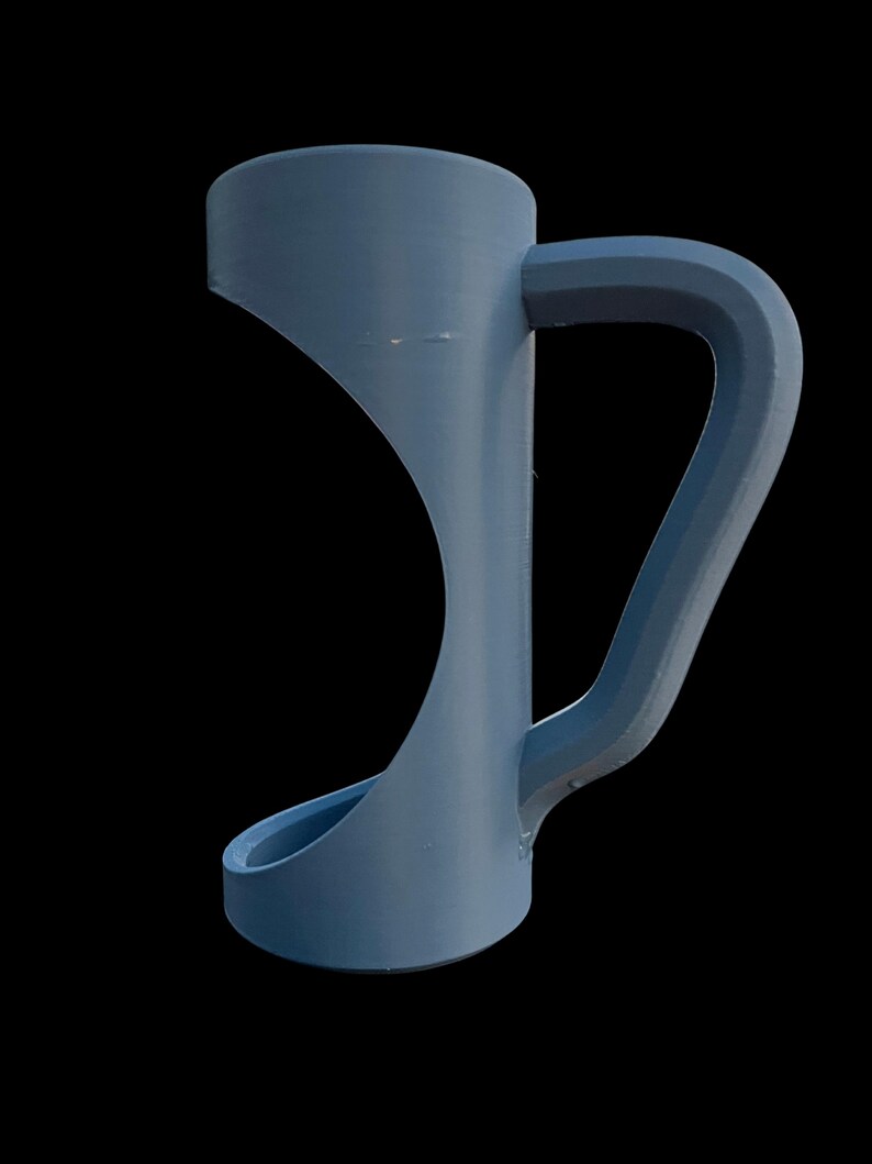 May include: A blue mug with a unique, modern design. The mug features a cylindrical top, a curved handle, and a flared base. The handle is integrated into the body of the mug, creating a seamless look. The mug is made of a solid material.