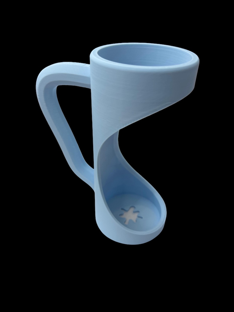 May include: A light blue mug with a unique, curved design. The handle is integrated into the body, creating a continuous, flowing form. The base features a white star design. The mug is set against a black background.