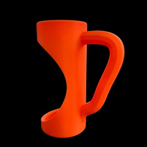 May include: Bright orange mug with a unique, curved design. The mug features a wide, flared base that tapers upwards to a narrower midsection, then widens again at the top. The handle is a thick, rectangular shape. The mug is set against a black background.