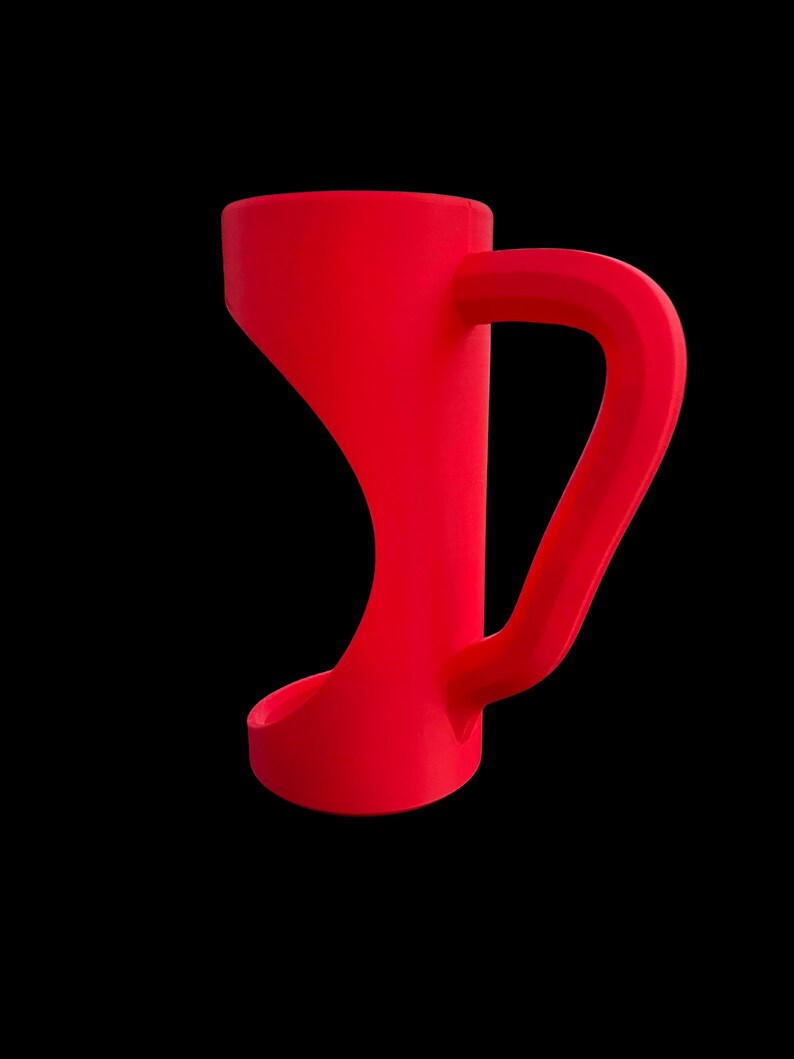 May include: A vibrant red mug with a unique, curved design. The mug features a distinctive handle and a flared base, set against a stark black background. The overall shape is modern and minimalist.