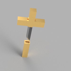 May include: A gold-colored cross with a black center piece. The cross is standing upright on a white surface.