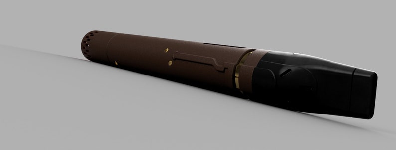 May include: A brown and black cylindrical vape pen with a gold accent. The pen has a mouthpiece on one end and a button on the other.