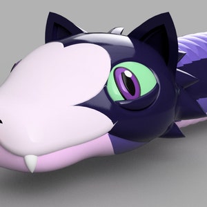 Puede incluir: Un juguete de serpiente morado y negro con una cabeza rosa y blanca, ojos verdes y una lengua roja. La serpiente tiene una cara de gato y una bola redonda verde al final de su cola.