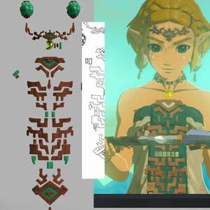 Op de afbeelding: Een groen en bruin gepatroneerd outfit met een groene edelsteen ketting en oorbellen. De outfit is geïnspireerd door het videospel "The Legend of Zelda: Breath of the Wild".