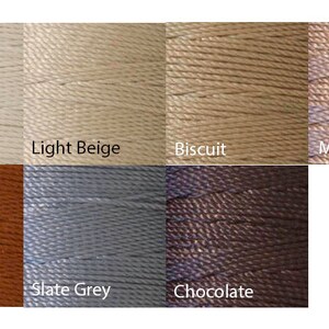 May include: A color palette of eight spools of thread, each in a different neutral shade. Colors include Eggshell, Light Beige, Biscuit, Mink, Copper, Slate Grey, and Chocolate. The thread is tightly wound and appears to be a smooth, durable material.