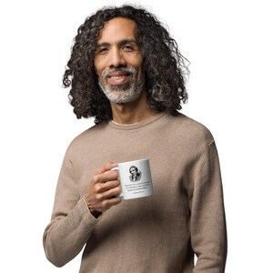 K&ouml;nnte beinhalten: Wei&szlig;e Keramik-Tasse mit einem Schwarz-Wei&szlig;-Portr&auml;t und Zitat von Thomas Paine. Das Zitat lautet: &bdquo;Die Pflicht eines wahren Patrioten ist es, sein Land vor seiner Regierung zu sch&uuml;tzen.&ldquo; Eine klassische Tasse f&uuml;r Tee oder Kaffee.