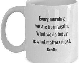 May include: White ceramic mug with a curved handle. The mug features the quote "Every morning we are born again. What we do today is what matters most." attributed to Buddha, in black text.