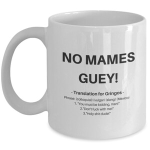 Puede incluir: Taza de caf&eacute; de cer&aacute;mica blanca con un gr&aacute;fico negro que dice "NO MAMES GUEY!" y una definici&oacute;n de la frase en espa&ntilde;ol e ingl&eacute;s.