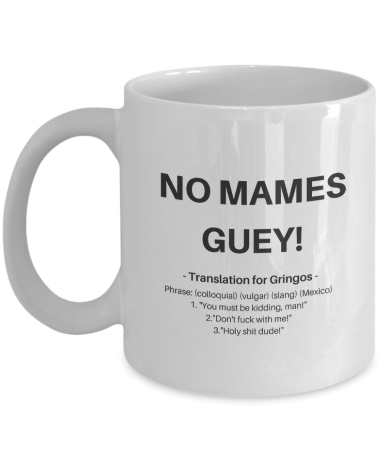 Puede incluir: Taza de caf&eacute; de cer&aacute;mica blanca con un gr&aacute;fico negro que dice "NO MAMES GUEY!" y una definici&oacute;n de la frase en espa&ntilde;ol e ingl&eacute;s.