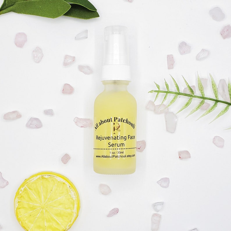 May include: A clear glass bottle with a white pump top filled with a yellow liquid. The bottle is labeled "All about Patchouli Rejuvenating Face Serum 1 oz / 30 ml www.AllAboutPatchouli.etsy.com".
