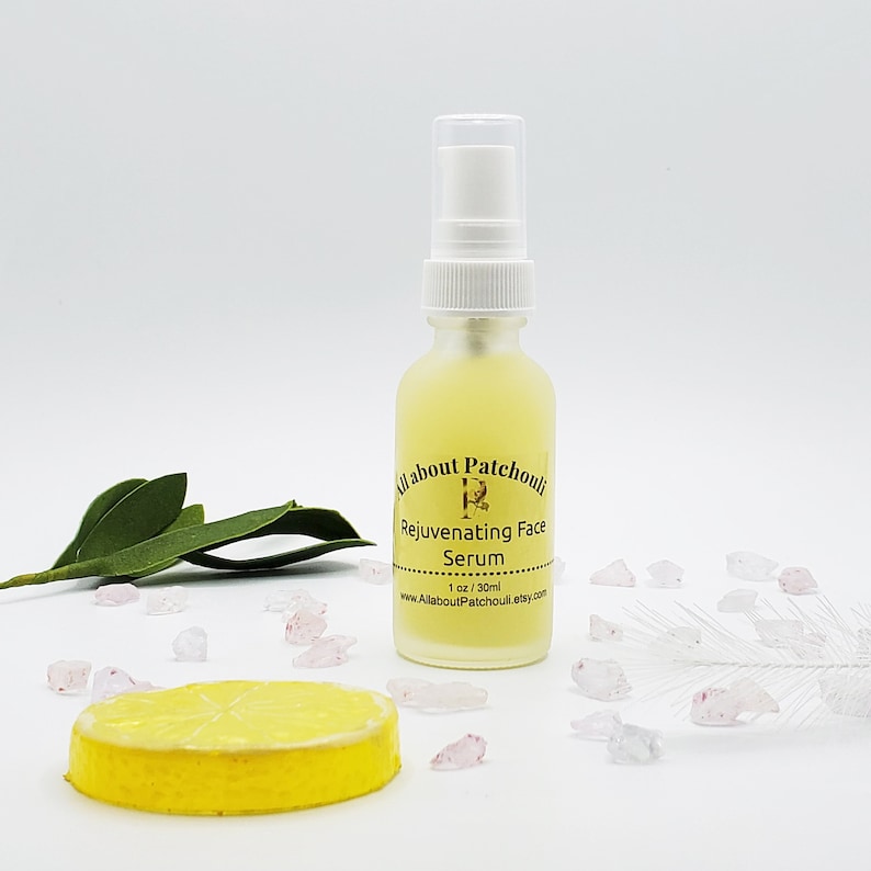 May include: A clear glass bottle with a white pump top filled with a yellow liquid. The bottle has a gold label that reads "All about Patchouli Rejuvenating Face Serum 1 oz / 30ml www.AllAboutPatchouli.etsy.com".