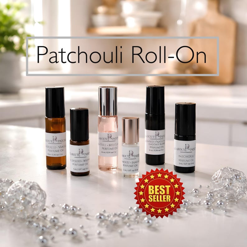 K&ouml;nnte beinhalten: Eine Auswahl an Roll-on-Parf&uuml;m&ouml;len in Glasflaschen mit schwarzen Kappen. Die Flaschen sind mit dem Text "Patchouli Roll-On" und verschiedenen D&uuml;ften beschriftet. Ein "Best Seller"-Aufkleber ist sichtbar. Der Hintergrund ist eine helle K&uuml;chenumgebung.