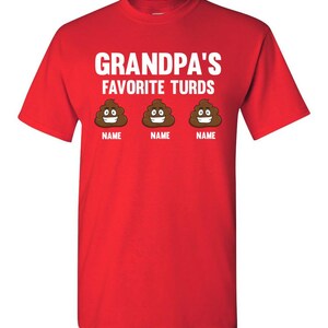 May include: Red t-shirt with the text "Grandpa's Favorite Turds" in white. Three cartoon poop emojis with smiling faces are below the text, each with the word "NAME" underneath.