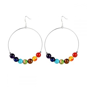 Puede incluir: Pendientes de aro de plata con siete cuentas de colores, que representan los siete chakras, en el orden de morado, azul oscuro, turquesa, verde, marrón, amarillo y rojo.