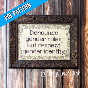 Peut inclure: Une broderie au point de croix encadrée avec un cadre en bois brun et un fond blanc. La broderie dit "Dénoncez les rôles de genre, mais respectez l'identité de genre." Le bas du cadre porte le texte "@DirtyCussStitch".