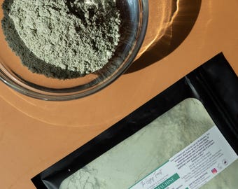 May include: A black pouch with a green powder inside. The pouch has a label that says "The Glowing Forest" and "Green Machine Clay Tonic Mask".