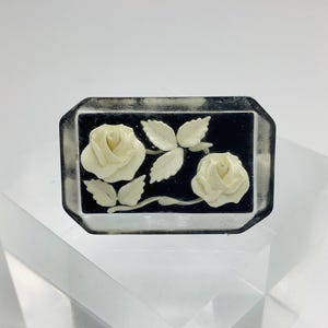 Broche antiguo de rosa blanca y negra tallada al reverso, de plástico Lucite, década de 1940.