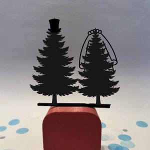 May include: A white ceramic mug with a black handle and the text "But First, Coffee" in a bold, black font. The mug is set against a blurred background, suggesting a cozy setting.