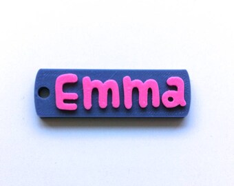 May include: A gray plastic keychain with a pink "Emma" name tag.