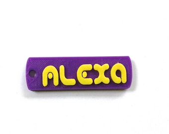 May include: Purple keychain with the name "ALEXA" printed in yellow letters.