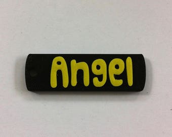 May include: Black rectangular keychain with the word "Angel" printed in yellow.