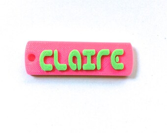 May include: A pink plastic keychain with the name "CLAIRE" in green letters.