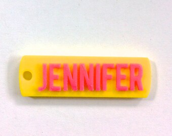 May include: A yellow plastic keychain with a pink inscription that reads "JENNIFER".