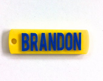 May include: A yellow plastic keychain with the name "BRANDON" printed in blue letters.