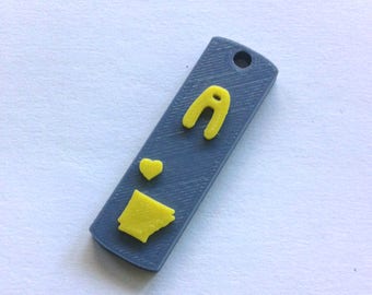 May include: A gray rectangular keychain with a yellow heart, a yellow outline of the state of Arkansas, and a yellow letter A.
