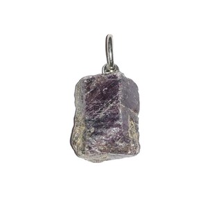 Pode incluir: Um pingente de pedra preciosa bruta de cor vermelho-púrpura profundo, com uma textura cristalina rugosa e facetas naturais. A pedra é fixada por uma argola de metal prateado no topo, projetada para ser usada em uma corrente ou cordão.