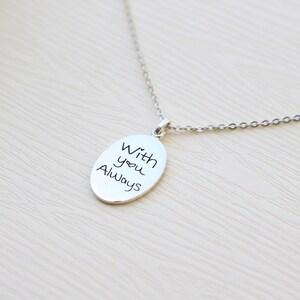 May include: Silver necklace with an oval pendant that says "With you Always" in handwritten script.