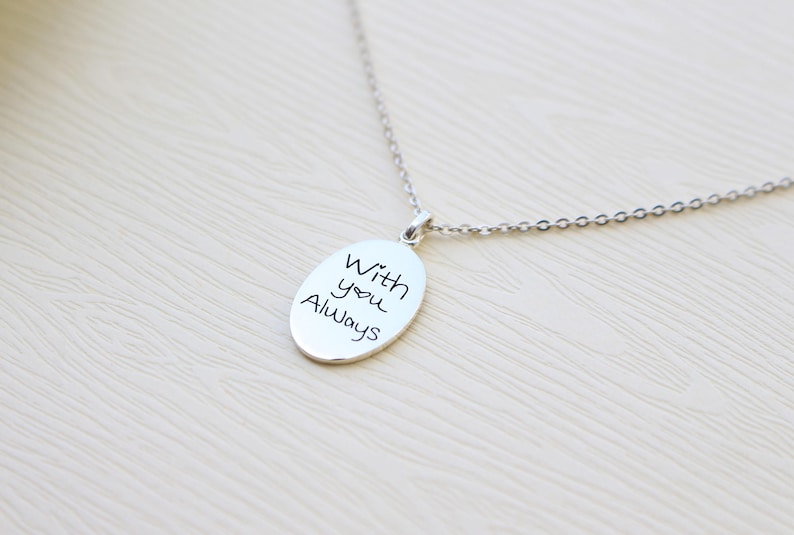 May include: Silver necklace with an oval pendant that says "With you Always" in handwritten script.