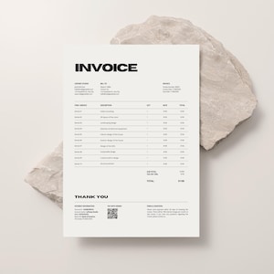 May include: A minimalist invoice with the bold word "INVOICE" at the top. The document includes sections for company information, itemized services, and a total. The invoice is on a white background, with a textured stone in the background.