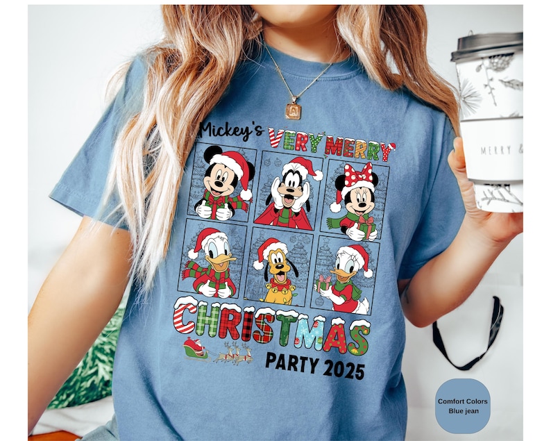 Puede incluir: Camiseta azul vaquero con un dise&ntilde;o de Mickey Mouse, Minnie Mouse, Donald Duck, Goofy y Pluto con ropa navide&ntilde;a. El texto "Mickey's Very Merry Christmas Party 2025" est&aacute; impreso en la camiseta.