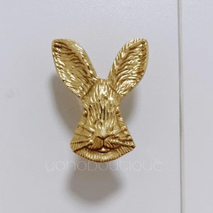 Könnte beinhalten: Goldfarbener Türknauf aus Metall in Form eines Kaninchenkopfes mit detailliertem Design.