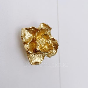 Peut inclure: Un bouton de porte en forme de fleur de couleur dorée.