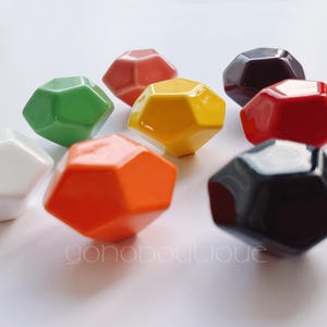 May include: Set of ten ceramic geometric knobs in various colors, including white, green, yellow, orange, red, and black. The knobs are shaped like diamonds and have a glossy finish.