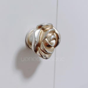 以下が含まれることがあります： 金と銀のバラの形をしたキャビネットノブ