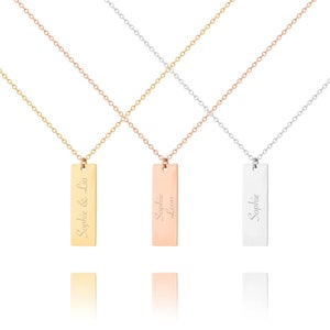 Könnte beinhalten: Drei Halsketten in Gold, Roségold und Silber mit personalisierten Bar-Anhängern. Der goldene Anhänger trägt die Aufschrift "Sophie & Lia", der roségoldene Anhänger "Sophie Leon" und der silberne Anhänger "Sophie".