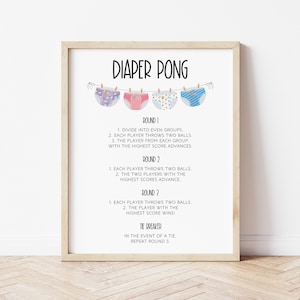 May include: A framed print with the title "DIAPER PONG" and the rules of the game. The print features illustrations of four different nappies hanging on a washing line. The text is in black font.