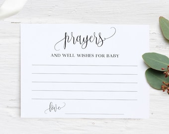 May include: A white card with black text that reads "prayers and well wishes for baby" with a blank space for writing. The card has a line at the bottom that says "love" with a blank space for a signature.