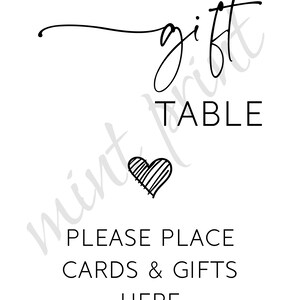 May include: Black and white sign with the text "gift table" and "please place cards & gifts here". A heart is drawn in the center of the sign.