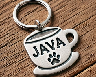 May include: Silver key chain with a coffee cup charm. The charm has the word "JAVA" and a paw print on it.
