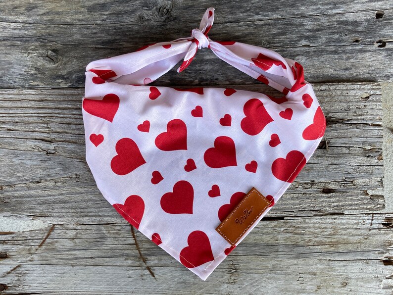 Puede incluir: Bandana blanca con estampado de corazones rojos y nudo. La bandana presenta un patr&oacute;n repetido de corazones rojos sobre fondo blanco. Una peque&ntilde;a etiqueta de cuero marr&oacute;n con la palabra "Willow" est&aacute; cosida en la esquina.