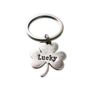 May include: Silver key chain with a four-leaf clover charm that says "Lucky" on it.
